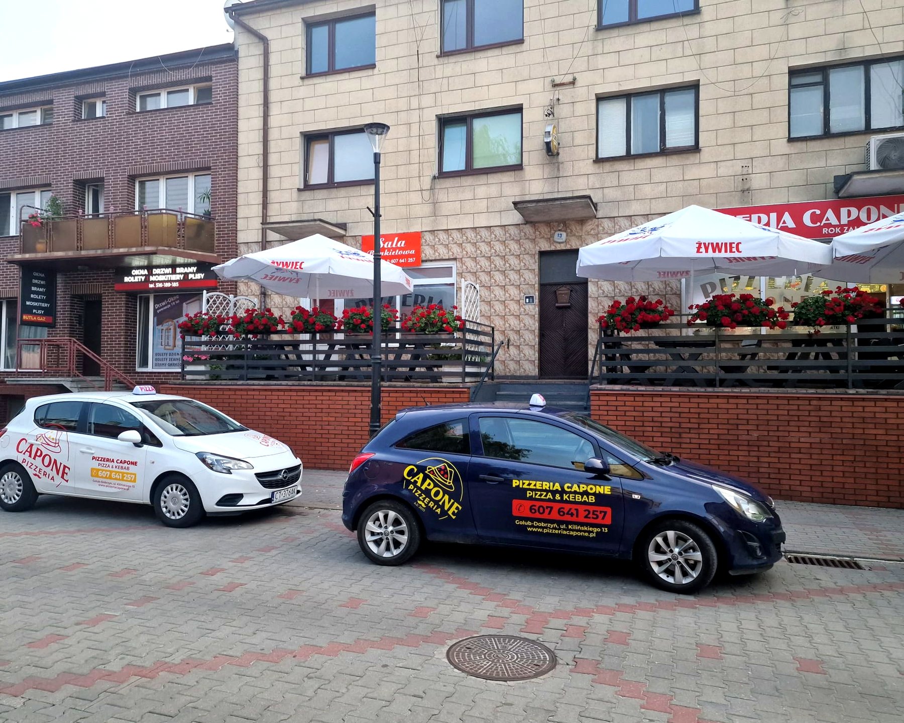 Pizzeria Capone przy Kilinskiego 13 w Golubiu-Dobrzyniu - taras i dwa auta dostawcze
